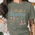 Green t-shirt with "Reading Is My Jam" text, an open book, and a mason jar graphic.