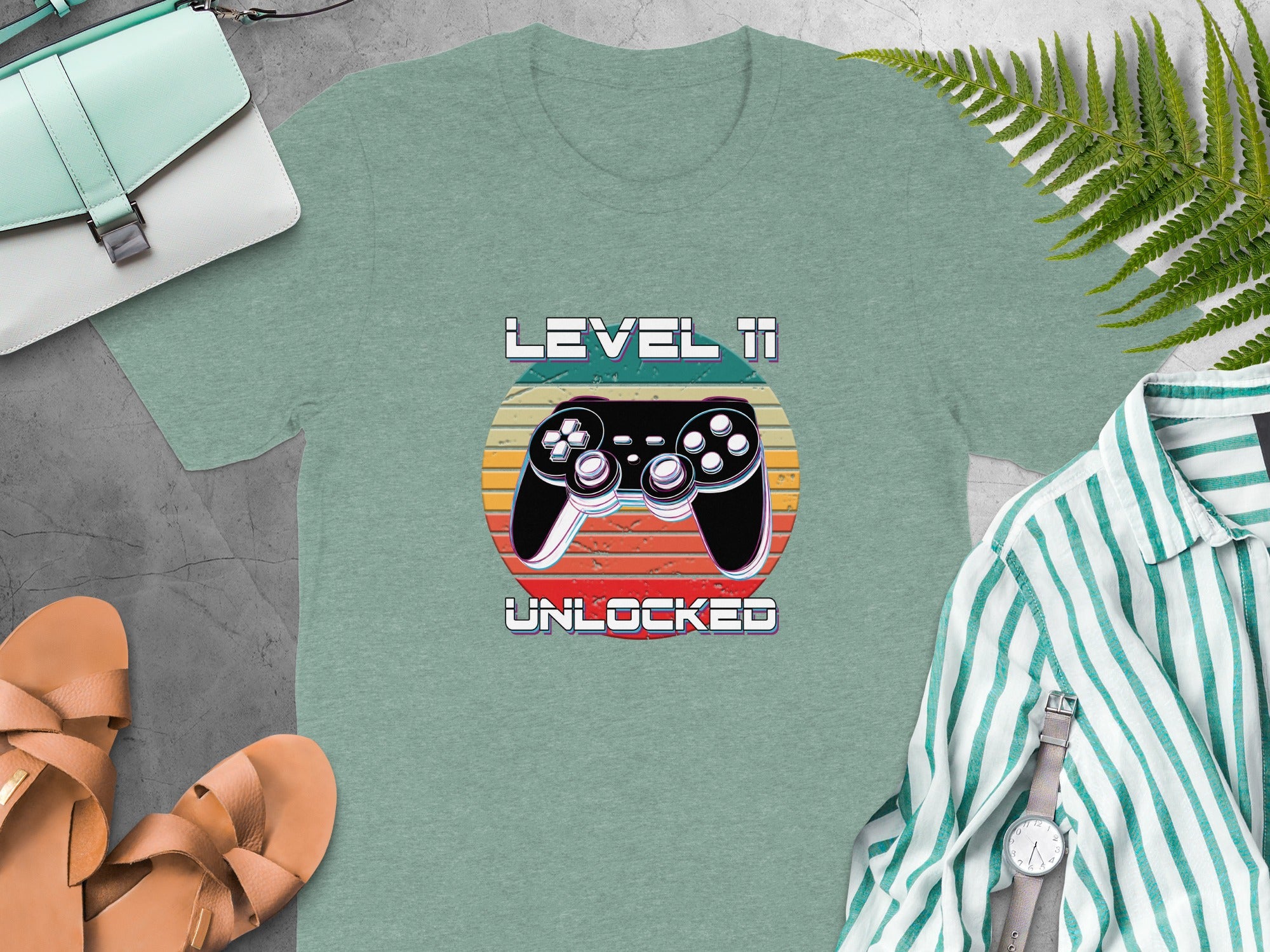 Green t-shirt with "Level 11 Unlocked" text and retro video game controller design.