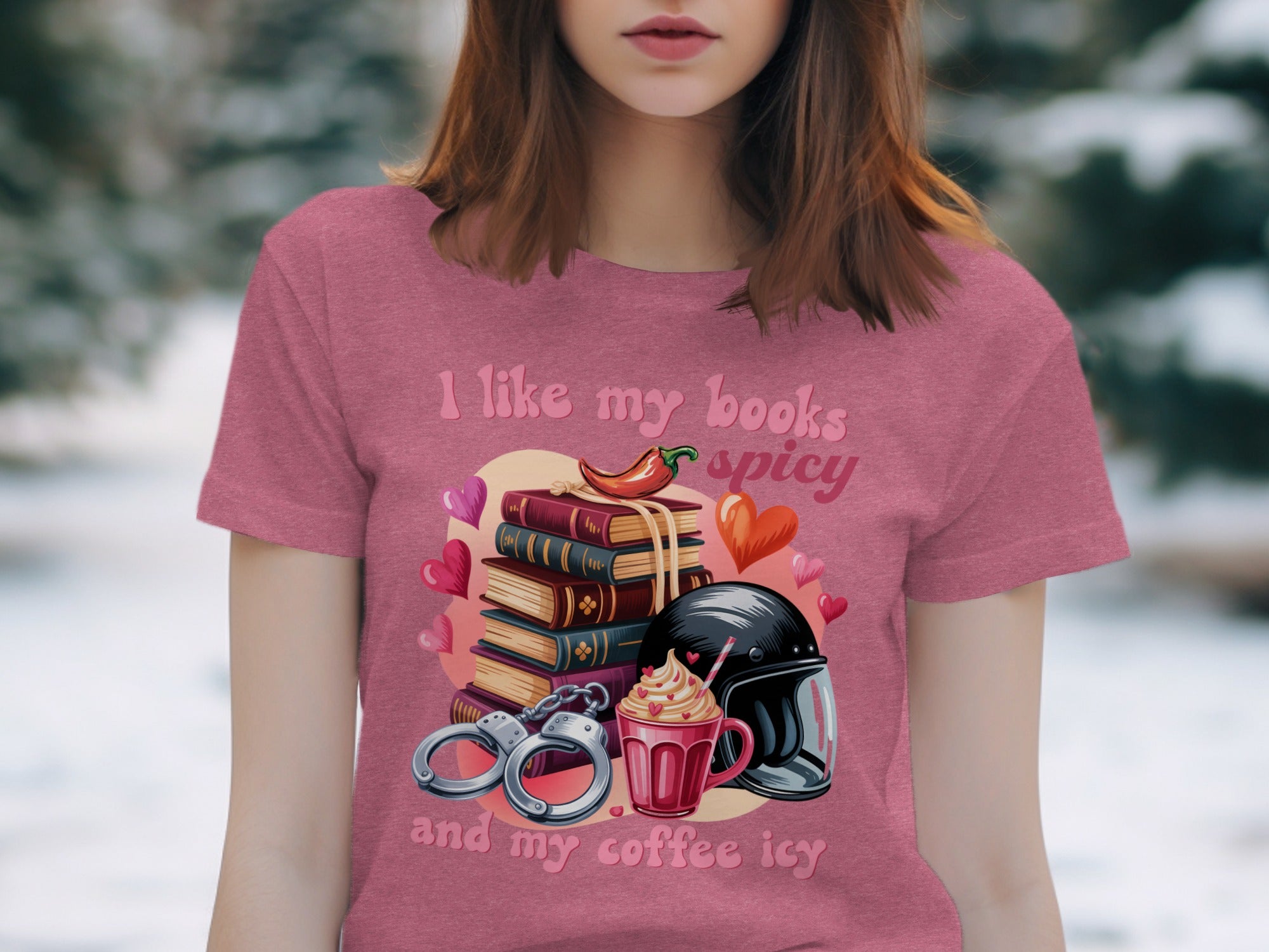 "I like my books spicy and my coffee icy" text on a pink shirt with books, chili, coffee, and handcuffs.