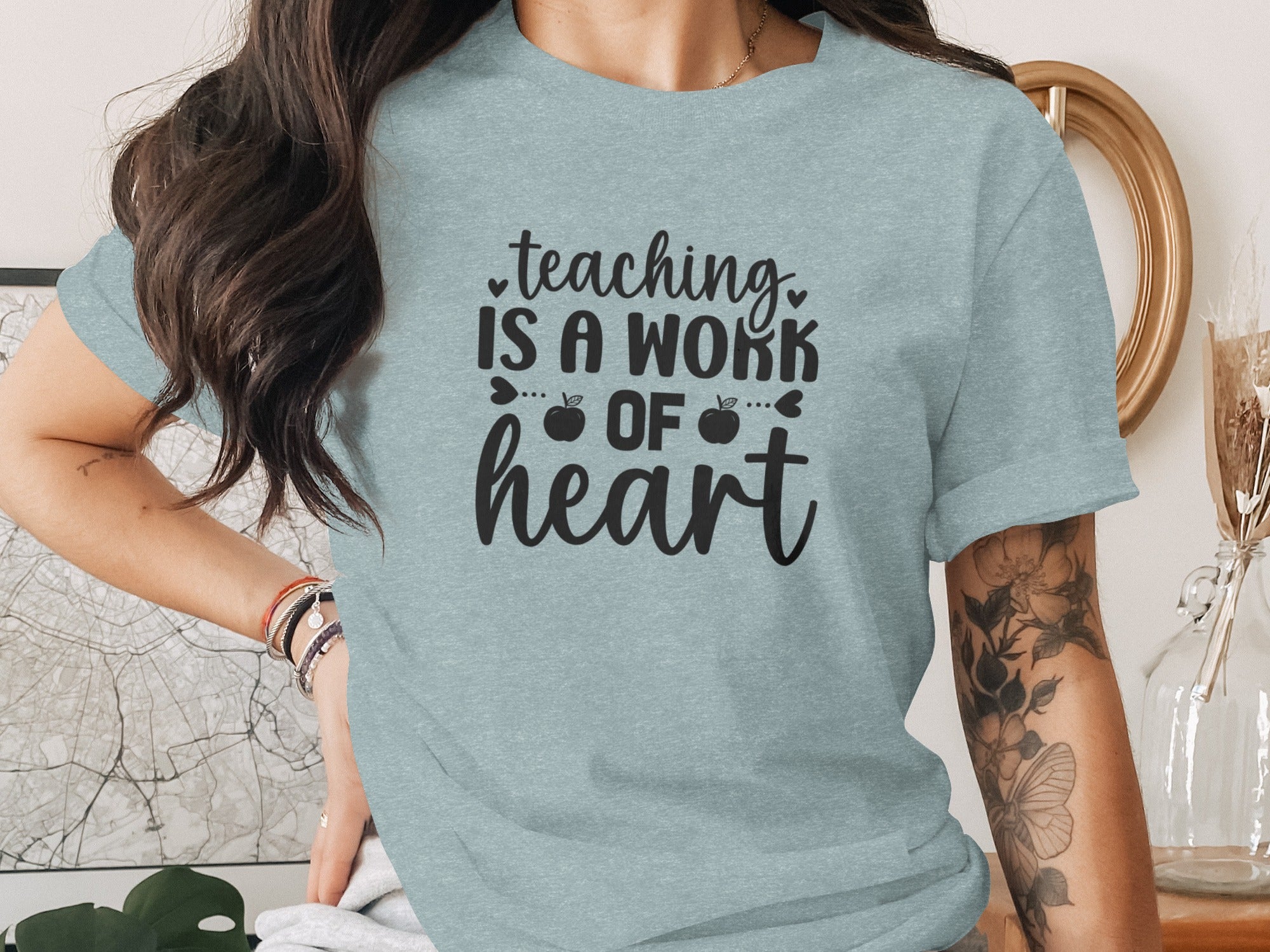 Light blue t-shirt with black text: "teaching IS A WORK OF heart"