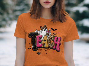 Orange t-shirt with "TEACH" text, a ghost, and Halloween elements.