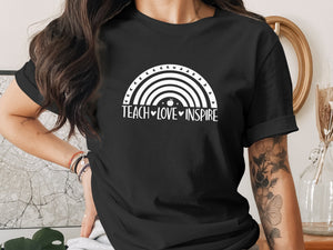 Black t-shirt with white rainbow design and text "TEACH LOVE INSPIRE".