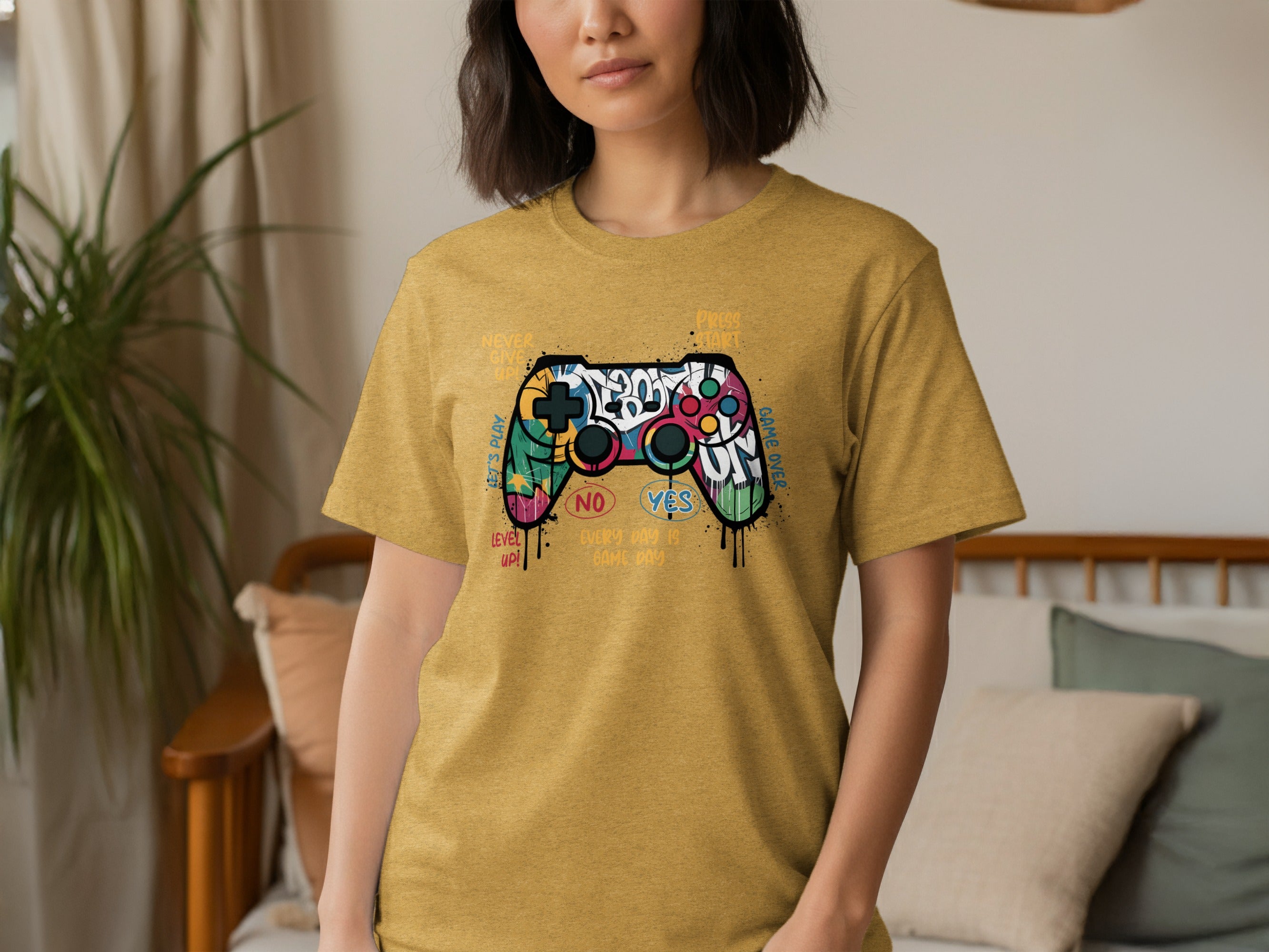 Yellow t-shirt with graffiti-style controller graphic and gaming text.