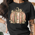 Black t-shirt print of a pumpkin made of vintage books with floral accents.
