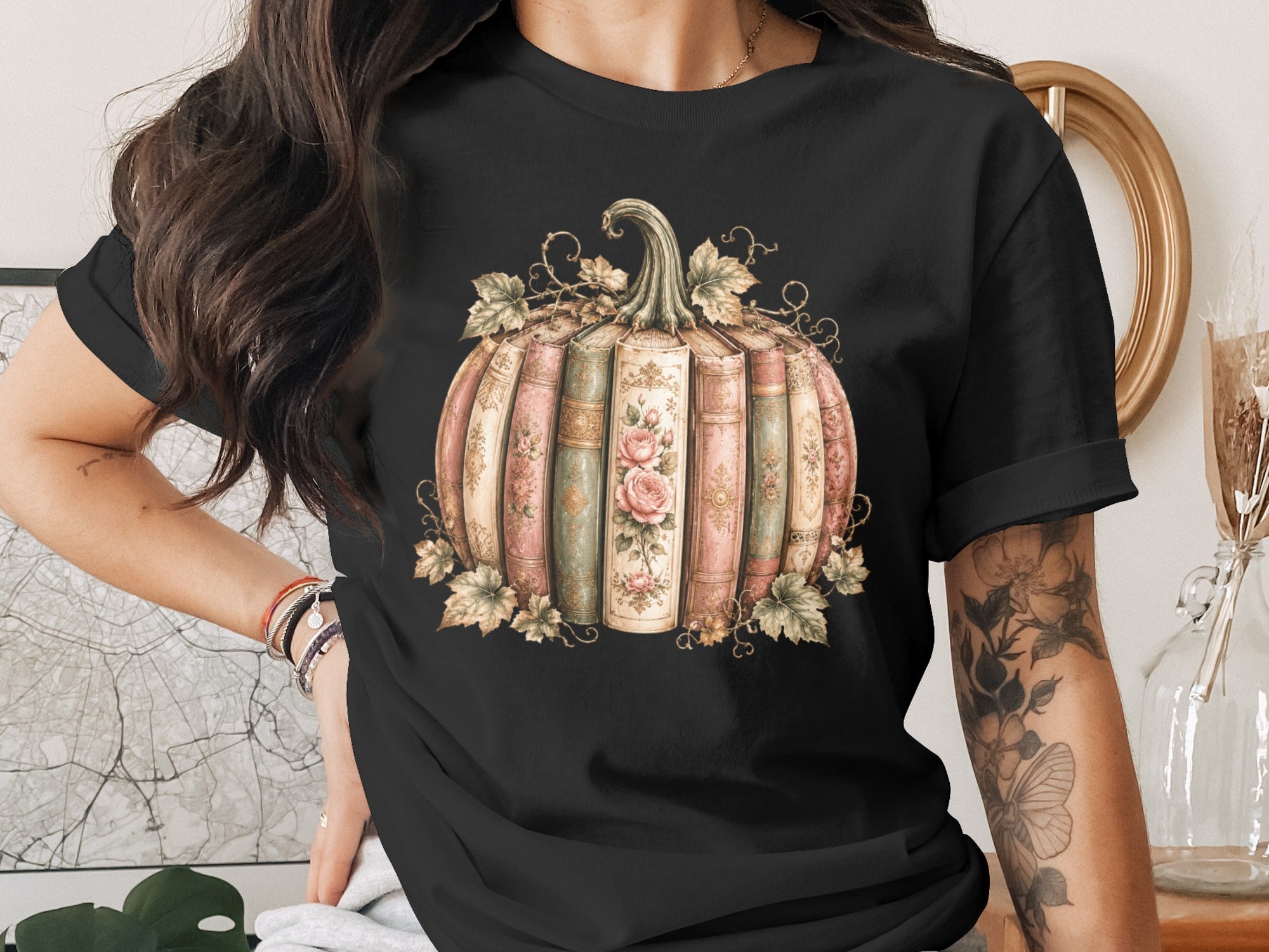 Black t-shirt print of a pumpkin made of vintage books with floral accents.
