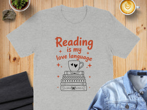Gray t-shirt with "Reading is my love language" text and stack of books with mug.