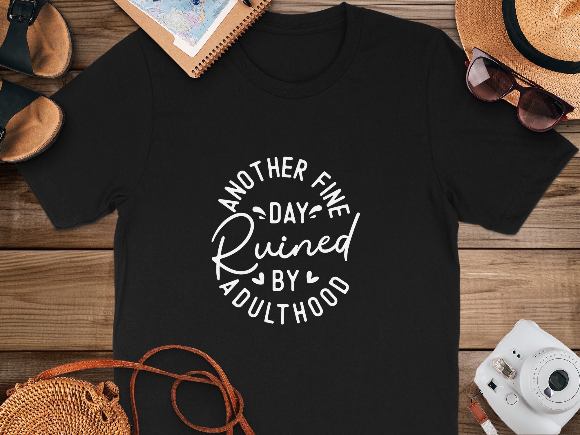 Black t-shirt with white text that reads "Another Fine Day Ruined By Adulthood".