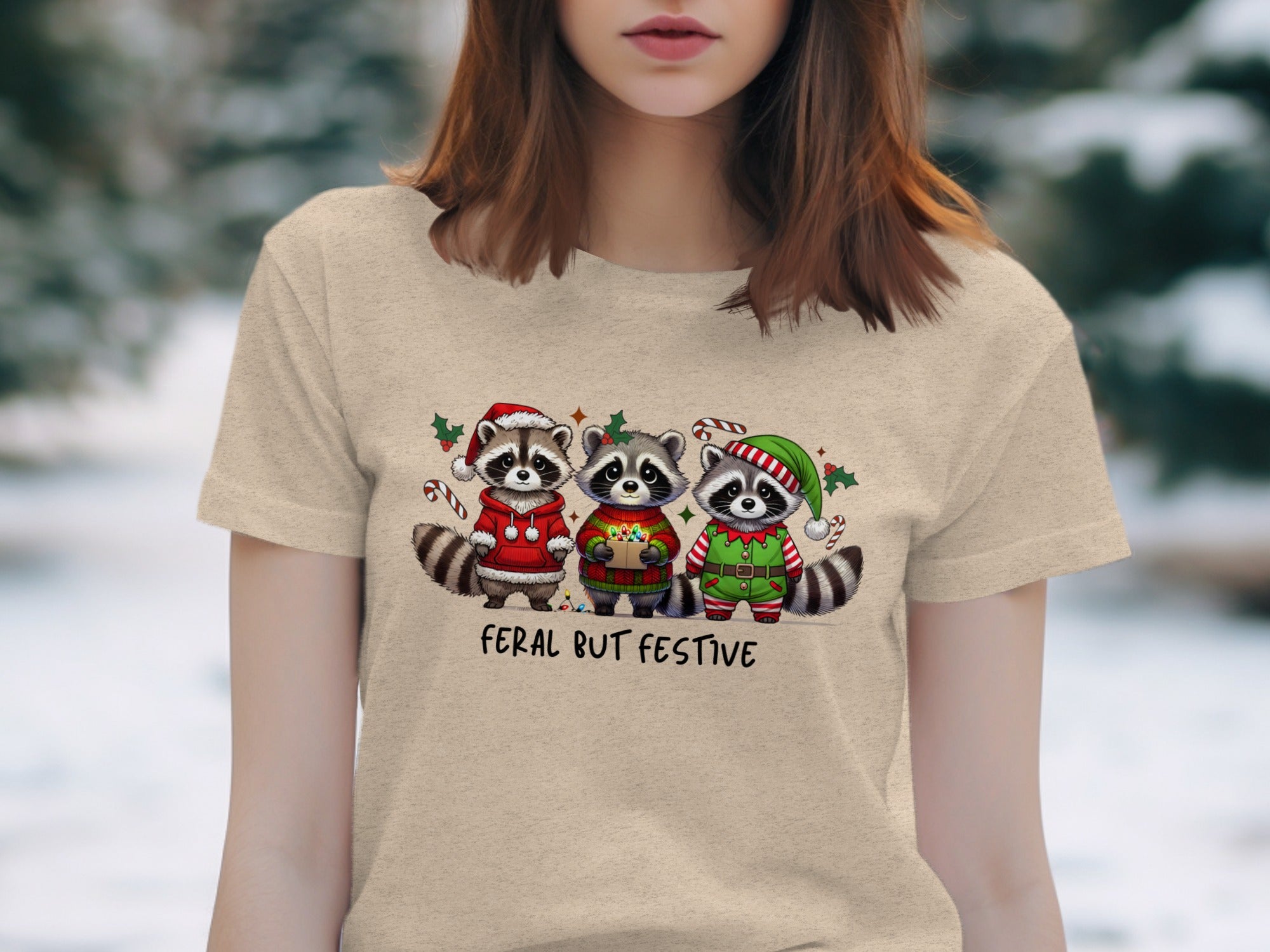 Three raccoons in holiday attire under text that reads "Feral But Festive."