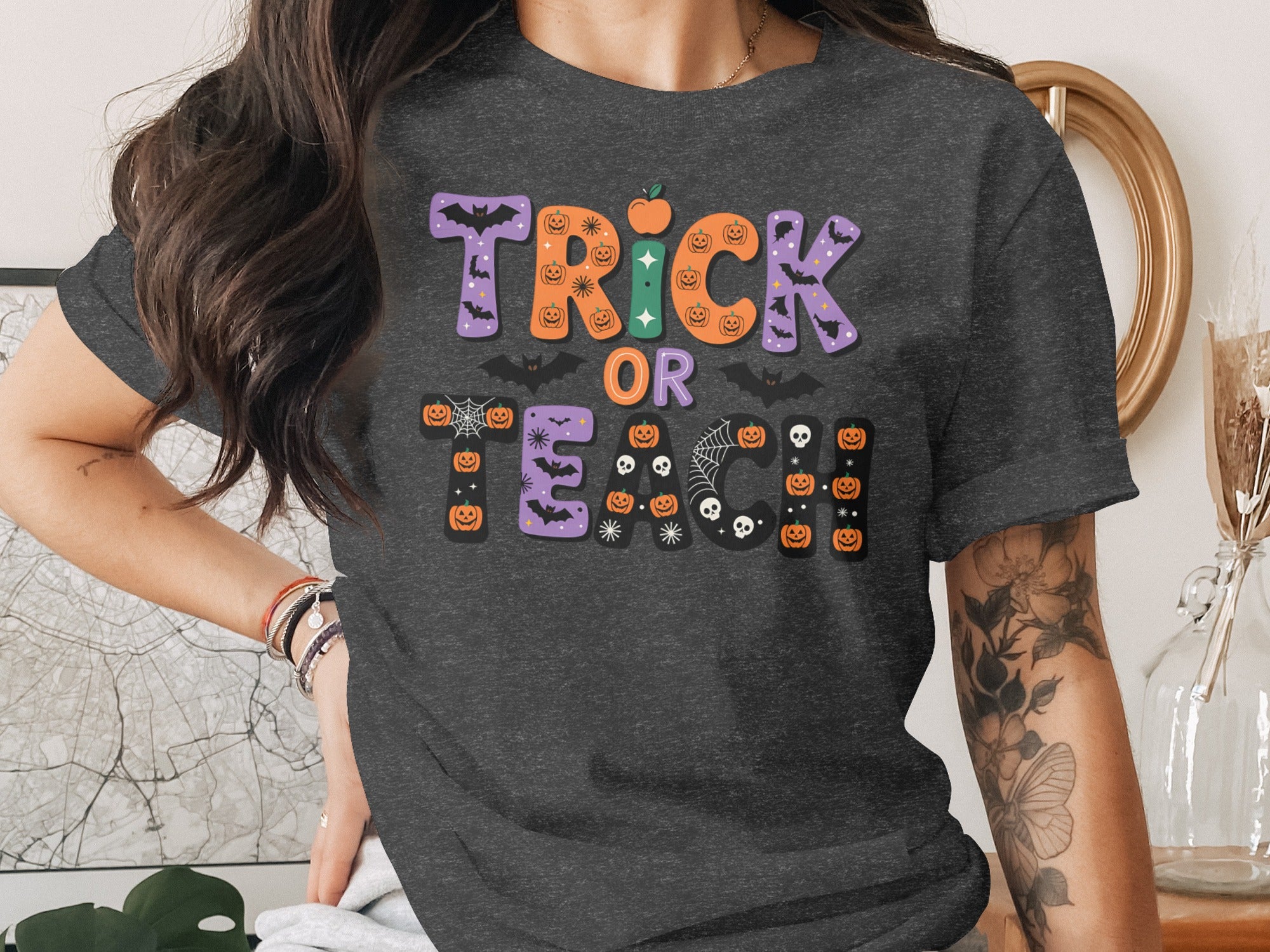 Dark gray t-shirt with "Trick or Teach" Halloween graphic featuring pumpkins and bats.