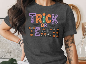 Dark gray t-shirt with "Trick or Teach" Halloween graphic featuring pumpkins and bats.