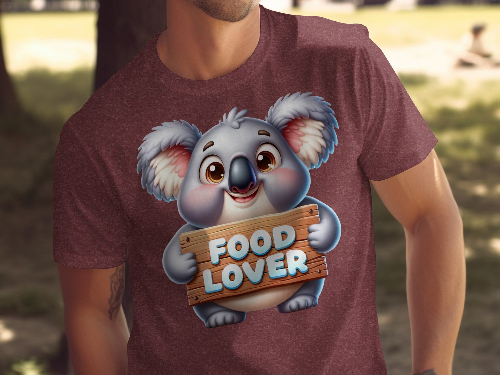 Cute cartoon koala holding a "FOOD LOVER" sign on a maroon t-shirt.