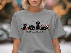 Four black cats tangled in Christmas lights with "merry catmas." text below.