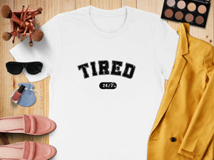 White t-shirt with "TIRED 24/7" text in black.