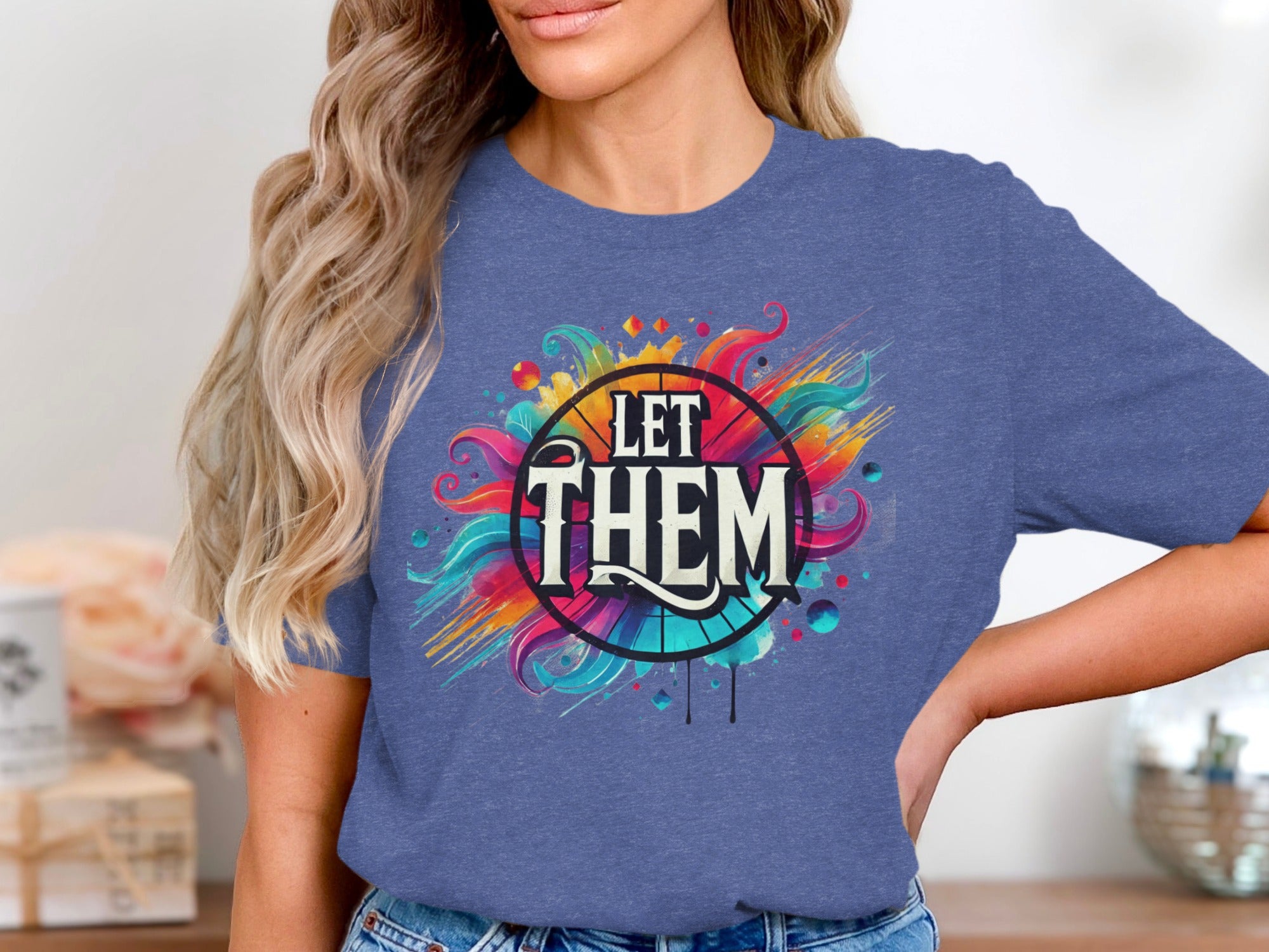 Blue t-shirt with colorful abstract design saying "LET THEM".