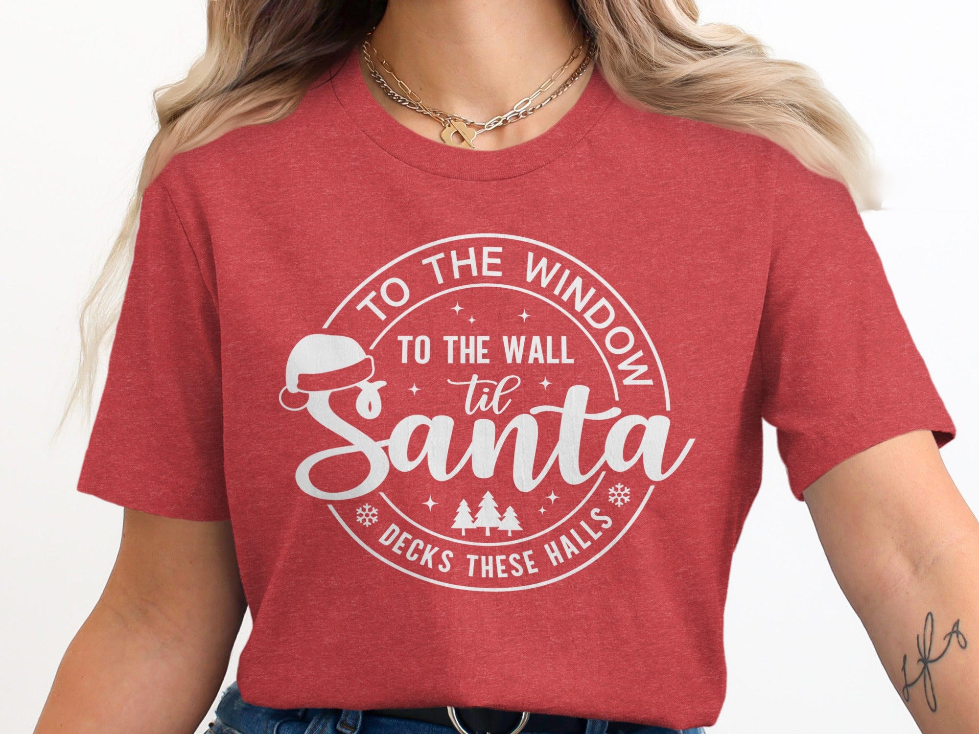 Red t-shirt with a circular graphic that says "To the window, to the wall, 'til Santa decks these halls".