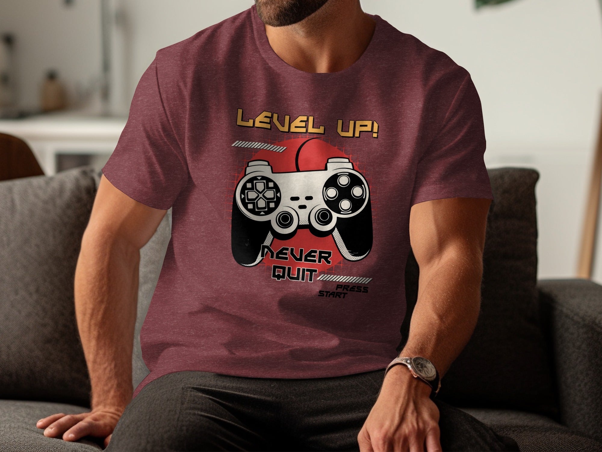 Maroon t-shirt with "LEVEL UP! NEVER QUIT PRESS START" and a retro video game controller graphic.