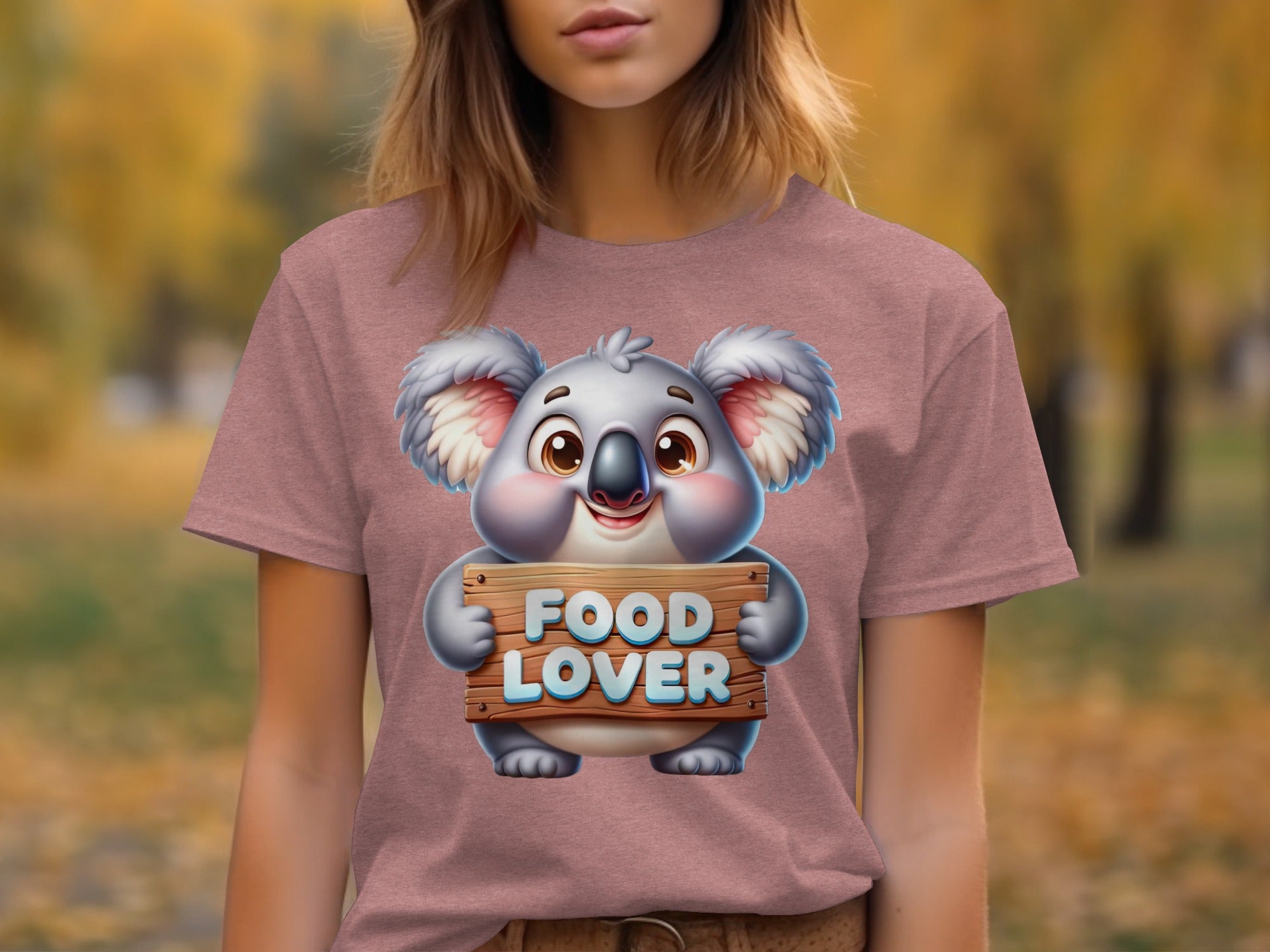 Cartoon koala holds a wooden sign saying "FOOD LOVER" on a t-shirt.