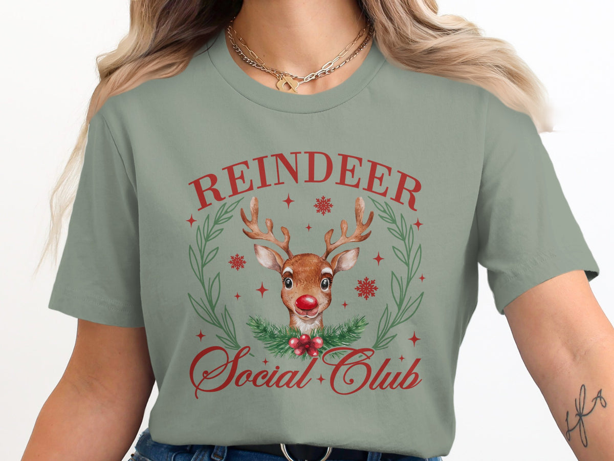 Green t-shirt with red text "Reindeer Social Club" and watercolor reindeer graphic.