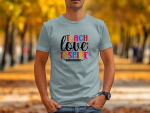 Teach love inspire text with pencil graphic on a light blue t-shirt.