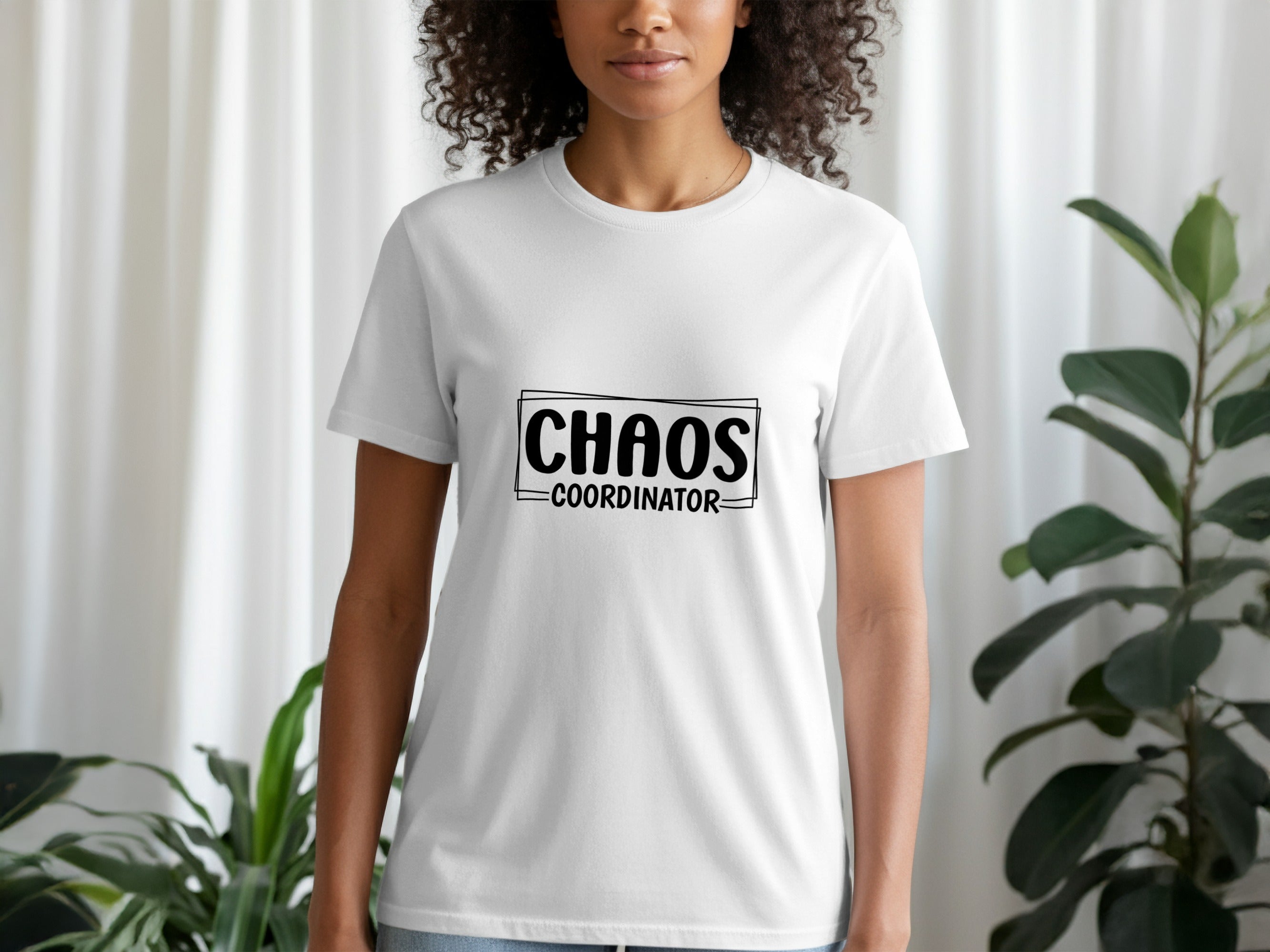 White t-shirt with black text "CHAOS COORDINATOR" in a rectangular border.