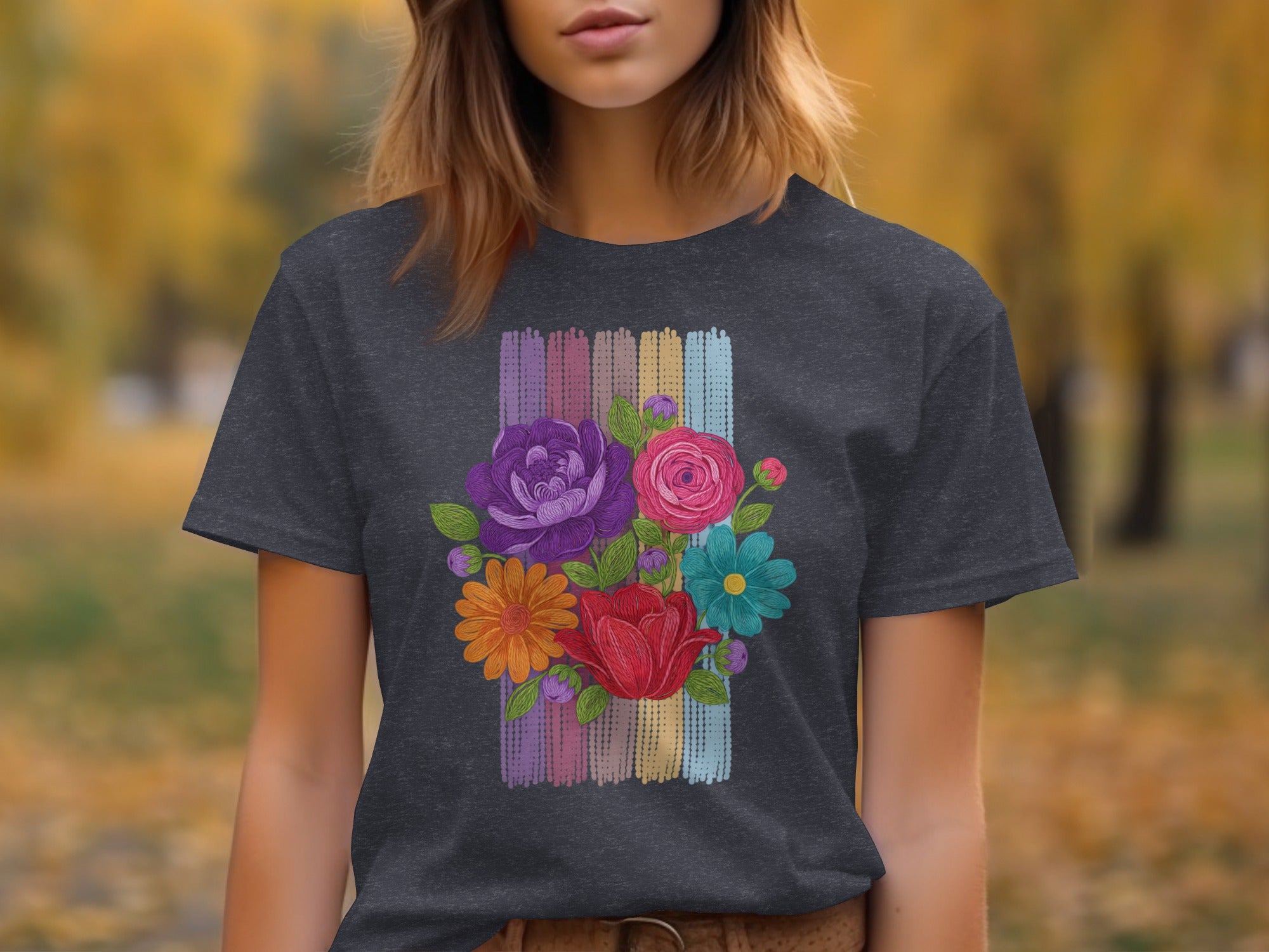 Dark gray t-shirt with colorful embroidered floral design on muted striped background.