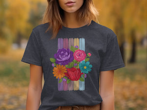 Dark gray t-shirt with colorful embroidered floral design on muted striped background.