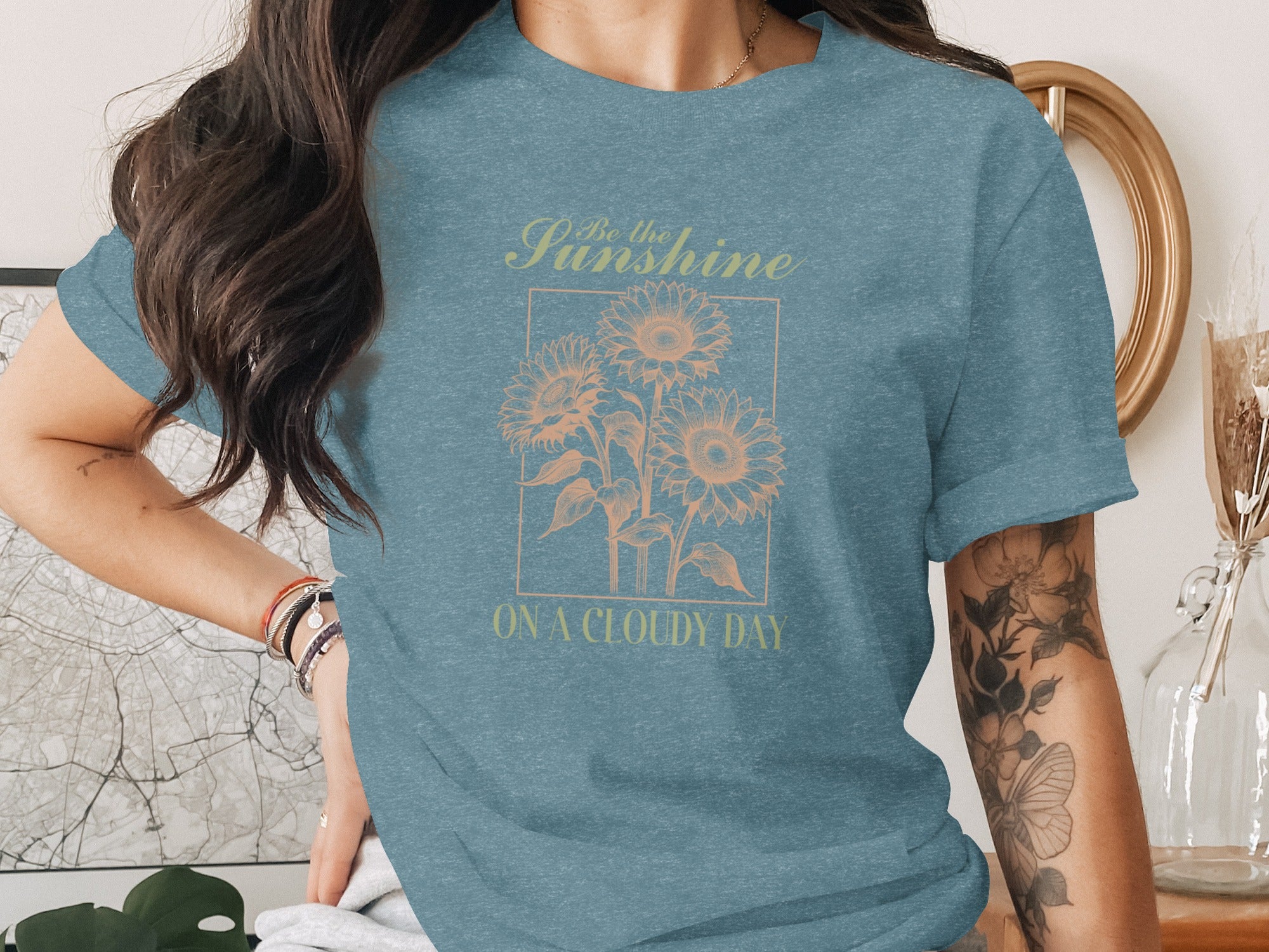 T-shirt with "Be the Sunshine ON A CLOUDY DAY" text and sunflower graphic.