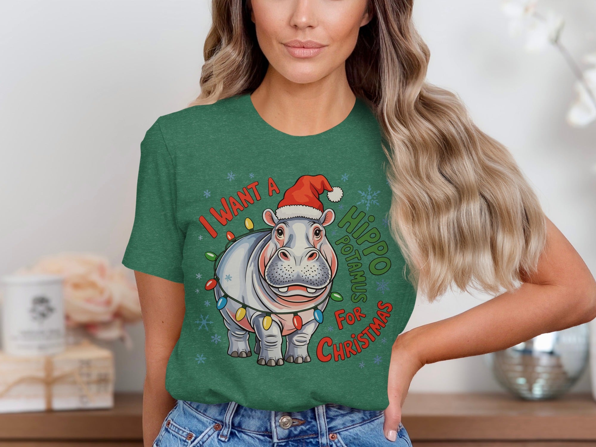 Green t-shirt with cartoon hippo wearing Santa hat and Christmas lights, saying "I Want A Hippo Christmas".
