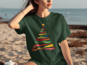 Green t-shirt with a multicolored watercolor Christmas tree and yellow star graphic.