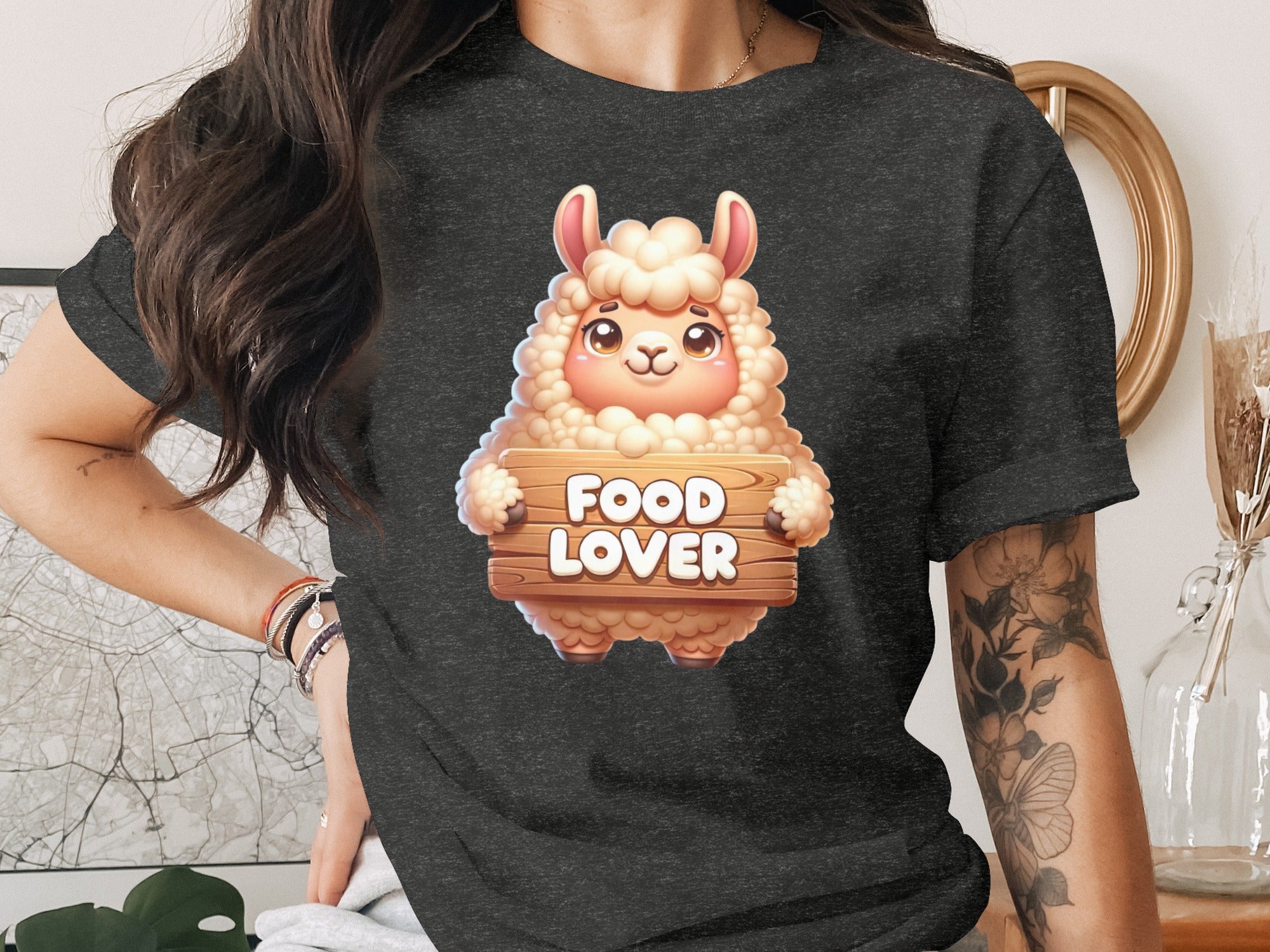 Cartoon llama holding a "Food Lover" wooden sign on a dark t-shirt.