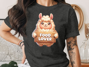 Cartoon llama holding a "Food Lover" wooden sign on a dark t-shirt.