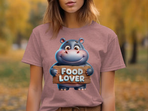 Cartoon hippo character on a pink t-shirt holding a wooden sign that says "FOOD LOVER".