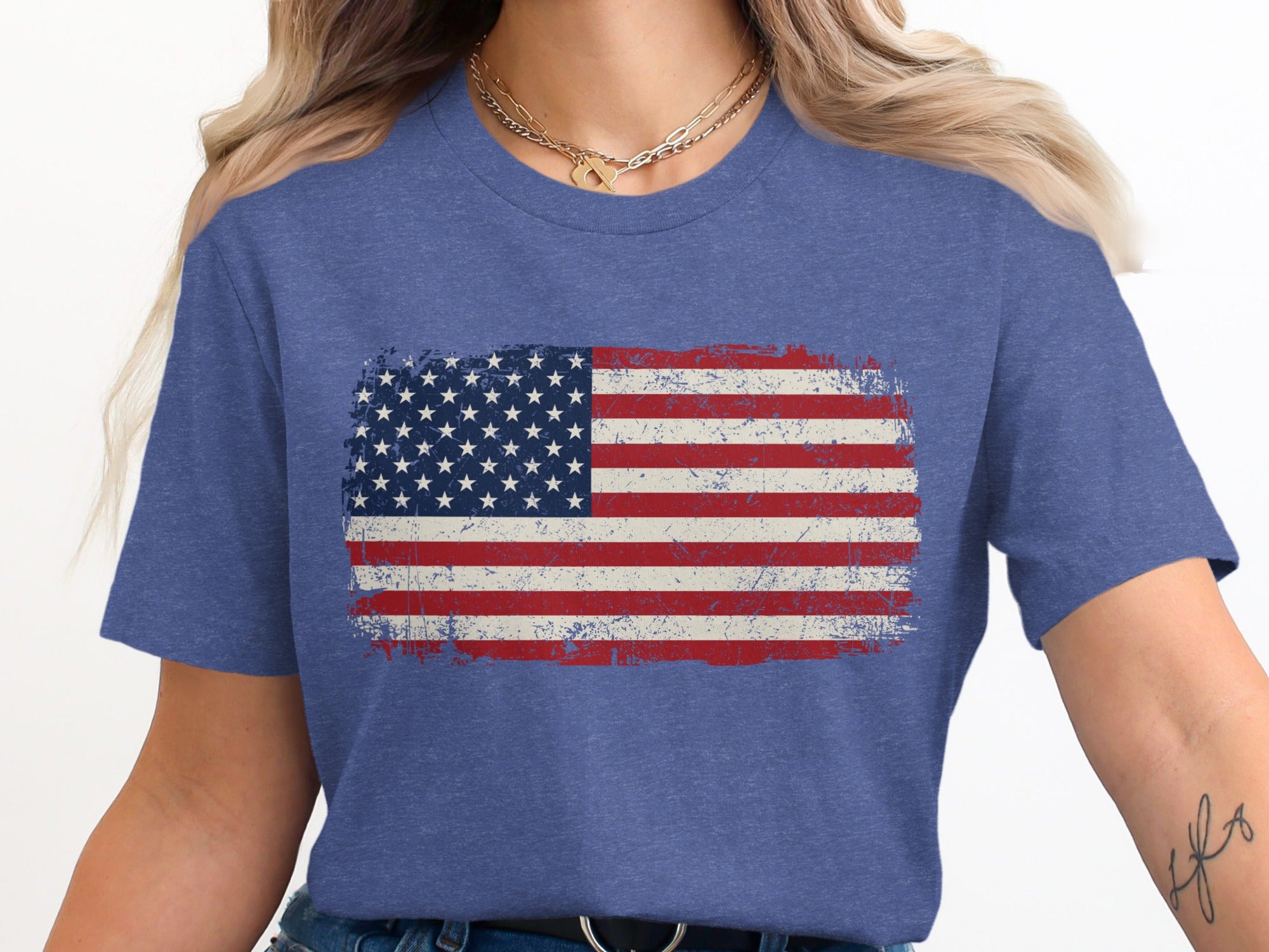 Distressed American flag graphic on a blue heather t-shirt worn by a woman.