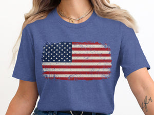 Distressed American flag graphic on a blue heather t-shirt worn by a woman.