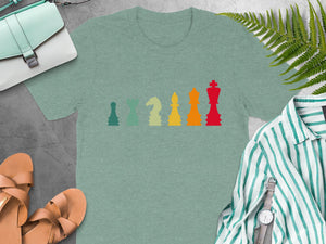 T-shirt with a colorful chess piece design, laid flat with accessories.
