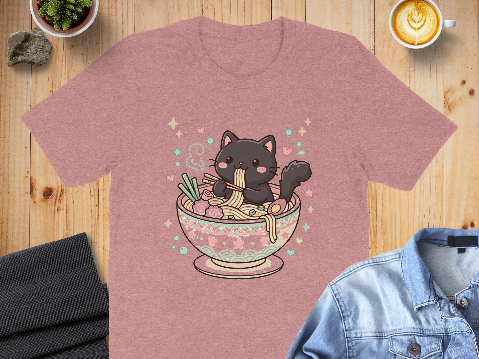 Pink t-shirt with a black cat eating ramen with chopsticks in a decorative bowl.
