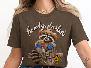 Raccoon in cowboy hat holding drink with "howdy, darlin'" text.