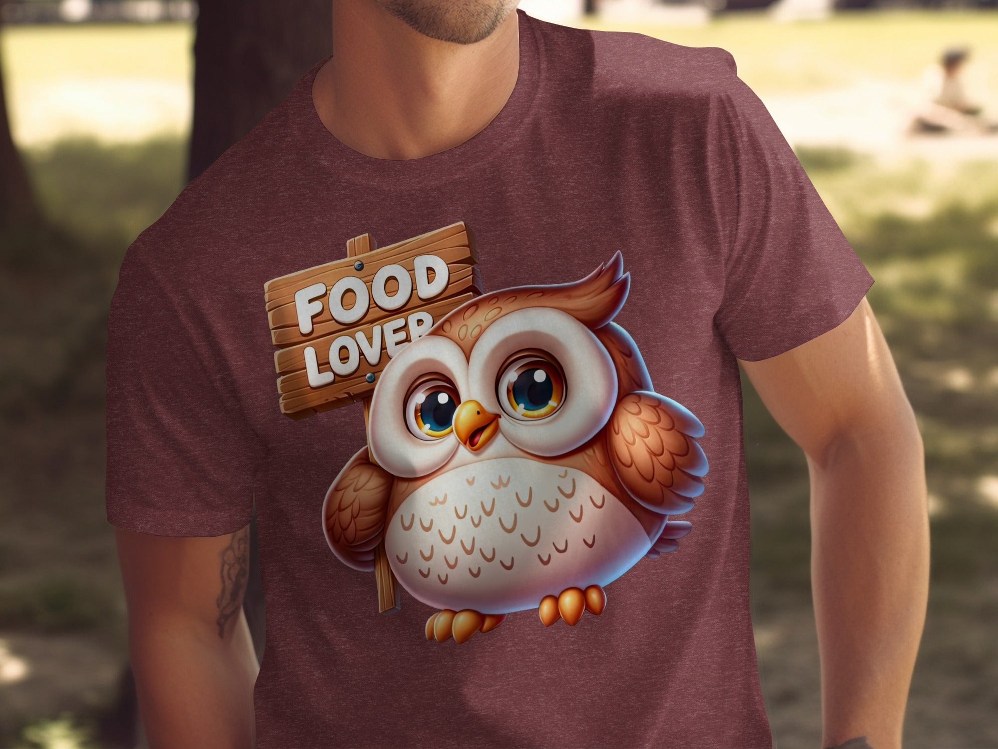 Cute owl with a wooden sign that says "FOOD LOVER" on a maroon t-shirt.
