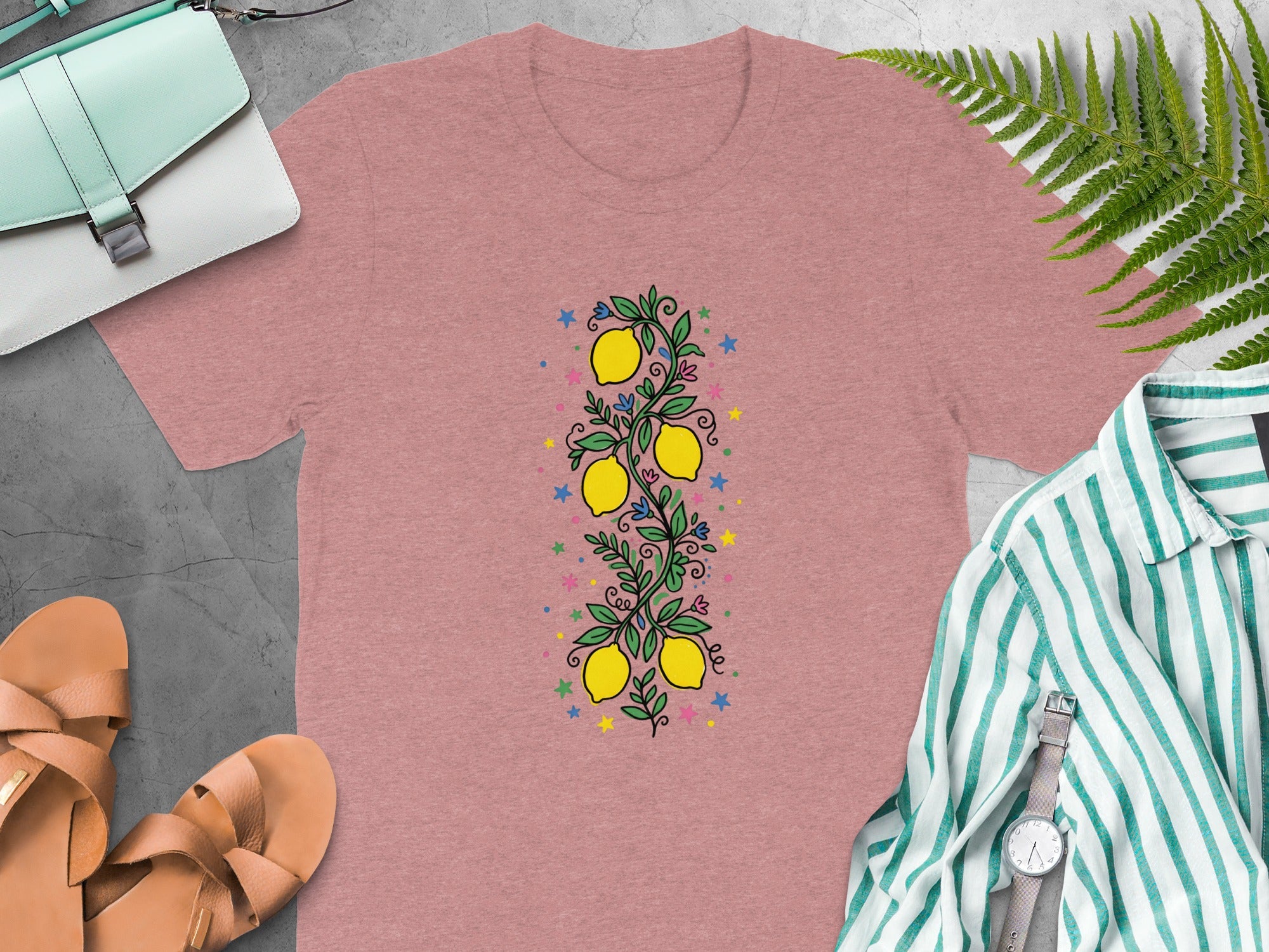Pink t-shirt with a central lemon branch design and colorful stars.