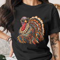 Black t-shirt featuring a colorful, bejeweled turkey wearing leopard print sunglasses.