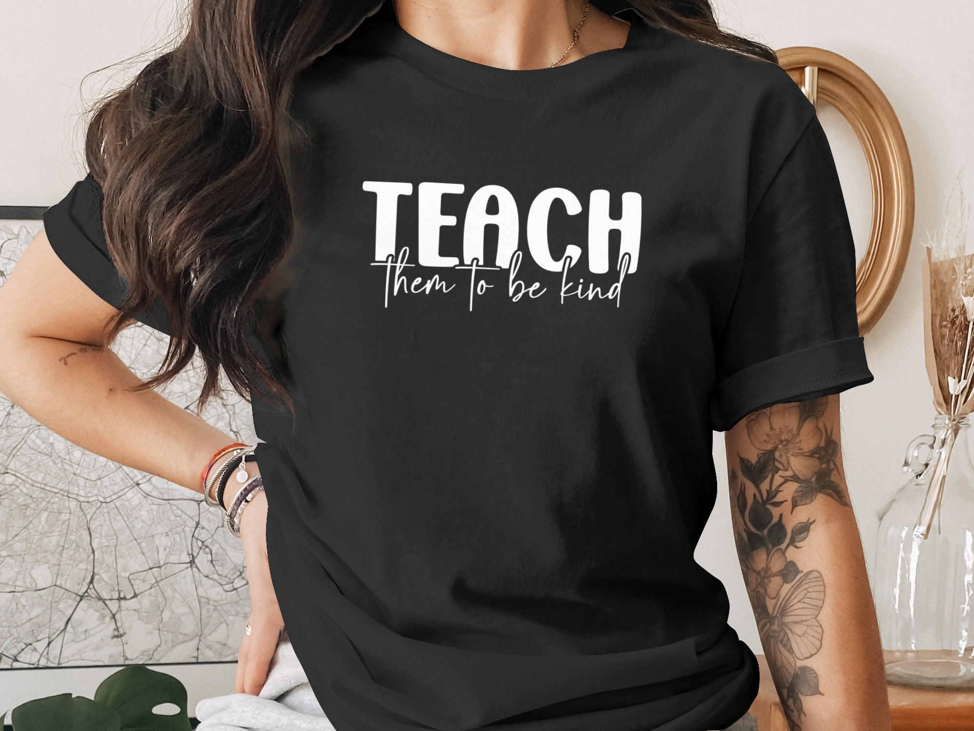 Black t-shirt with white text "TEACH them to be kind".