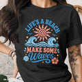 Black t-shirt with "Life's a Beach Make Some Waves" text and beach graphics.