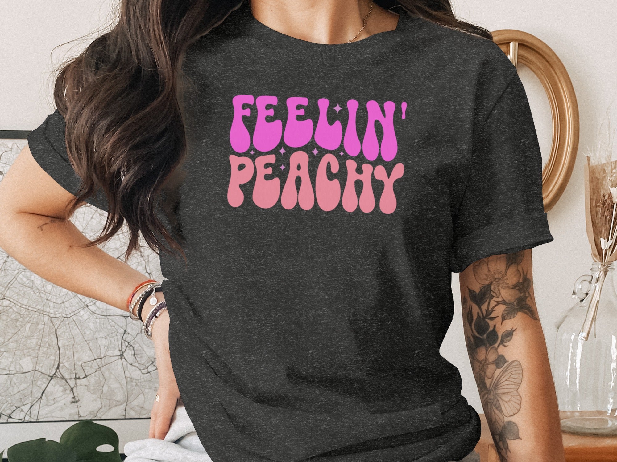 Dark grey t-shirt with pink and purple "Feelin' Peachy" text and stars design.