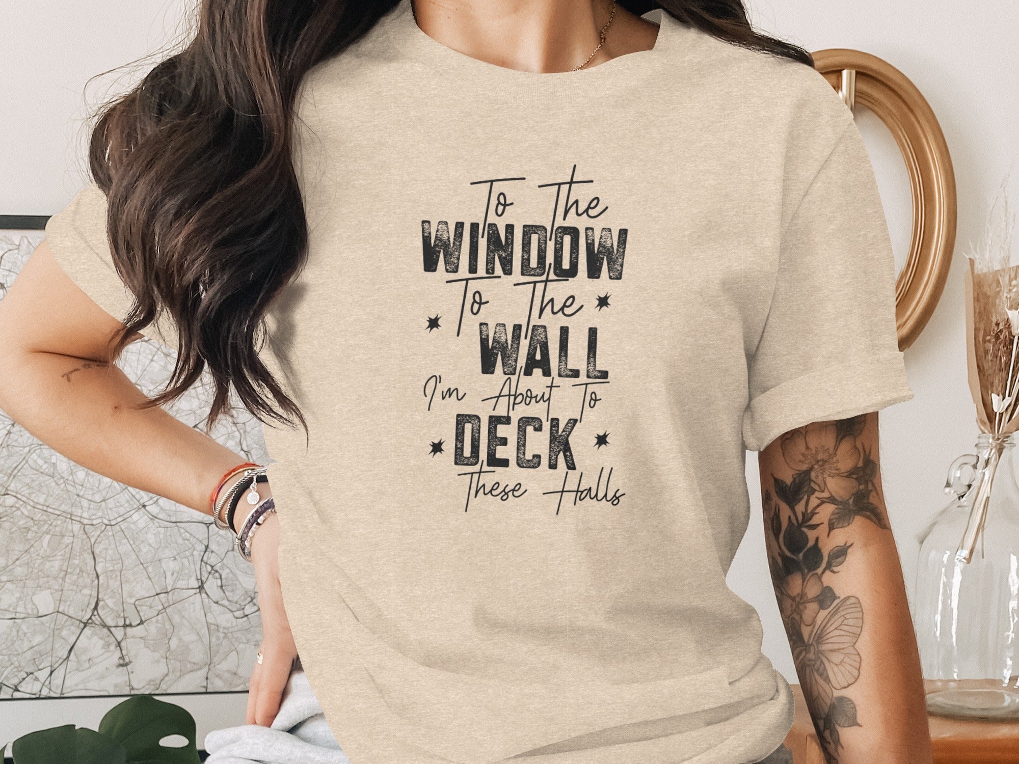 Light beige t-shirt with text "To the Window To the Wall I'm About To Deck These Halls".