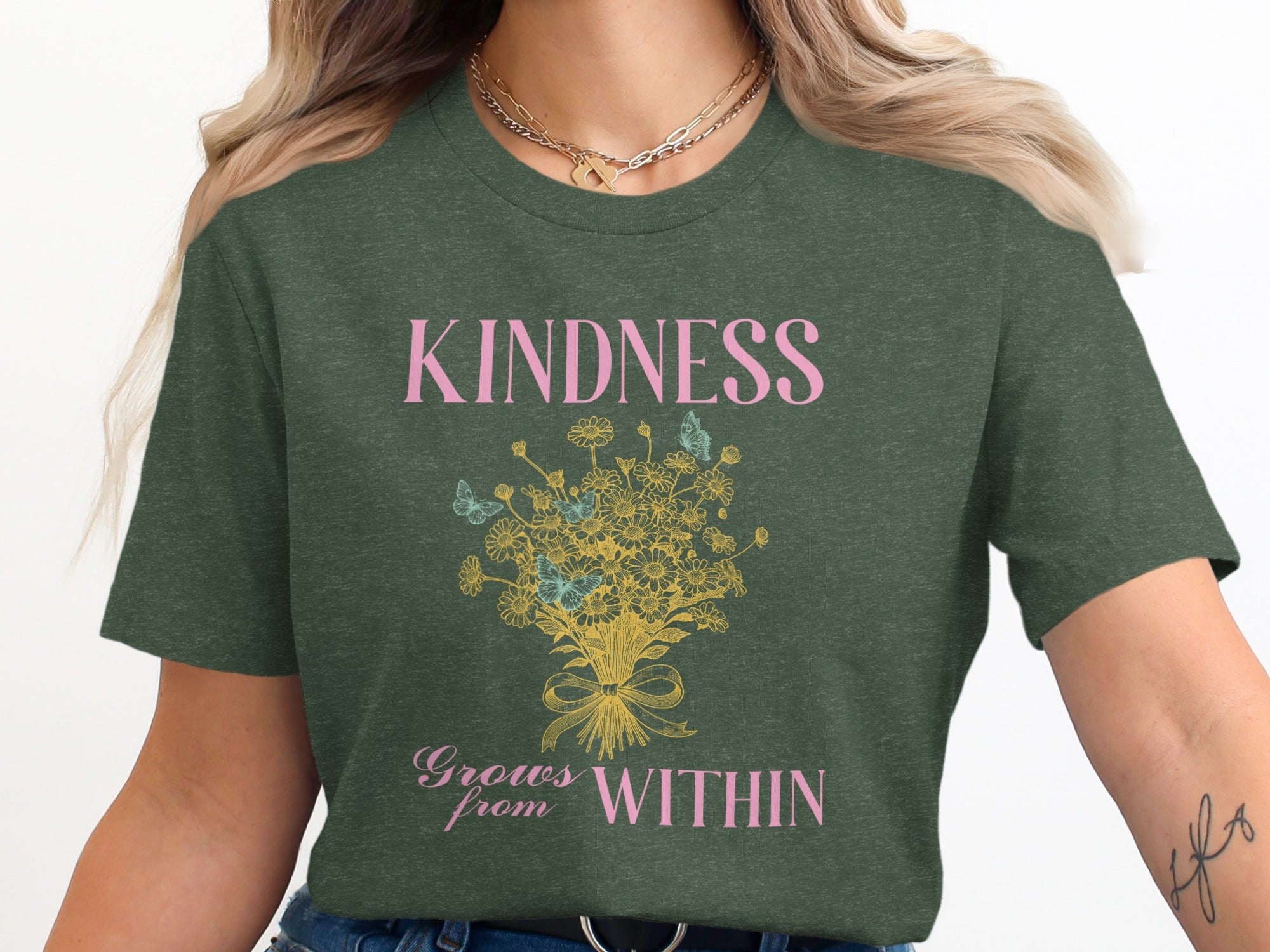 Dark green t-shirt with "KINDNESS Grows from WITHIN" text and floral graphic.