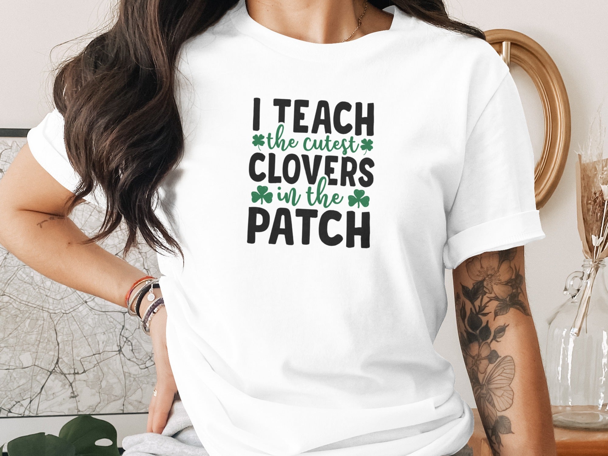 White t-shirt with black and green text saying "I TEACH the cutest CLOVERS in the PATCH".