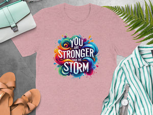 Pink t-shirt with colorful "You Are Stronger Than The Storm" graphic.