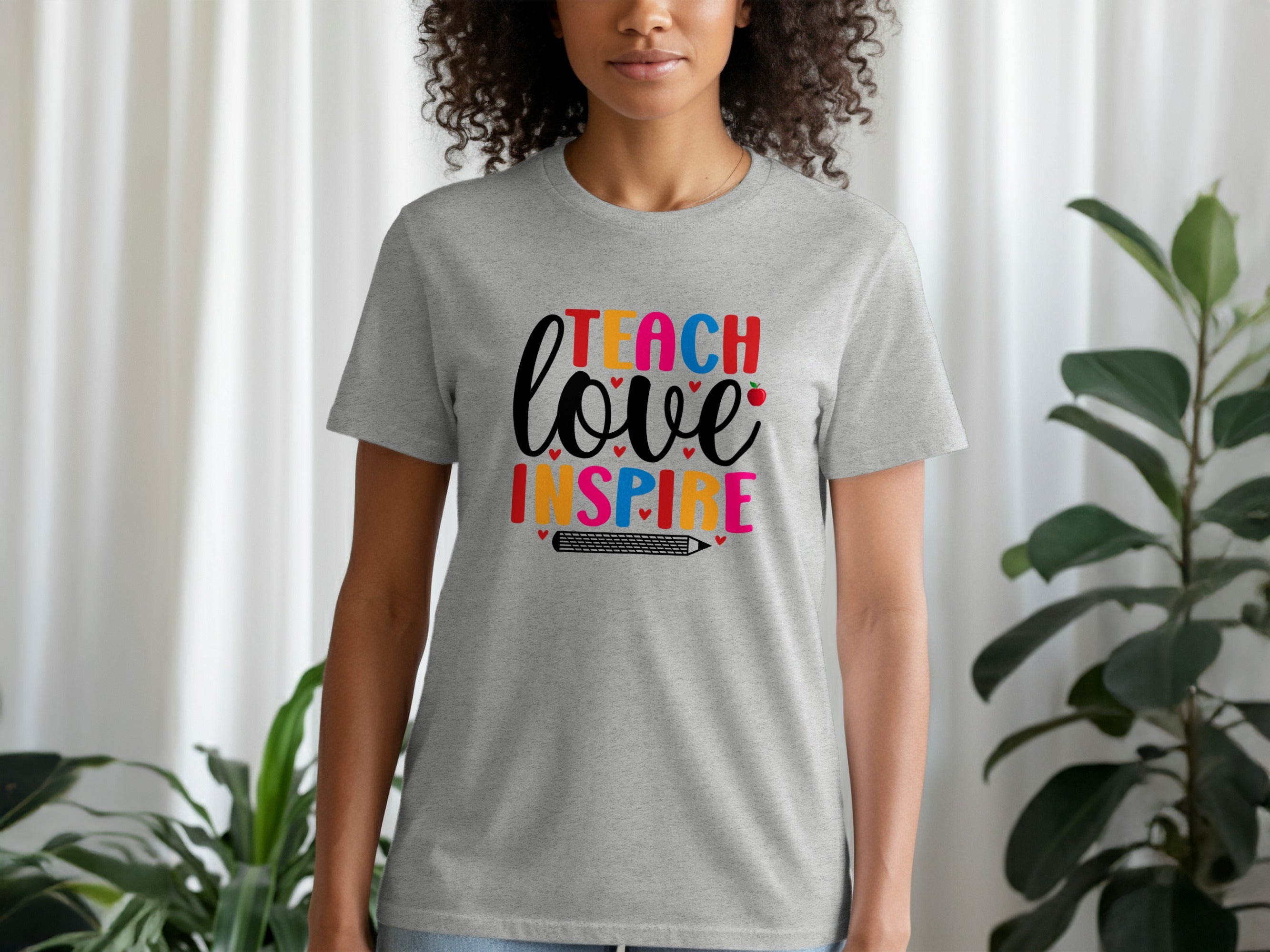 Gray t-shirt with colorful "Teach Love Inspire" text and pencil graphic.