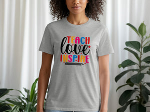 Gray t-shirt with colorful "Teach Love Inspire" text and pencil graphic.