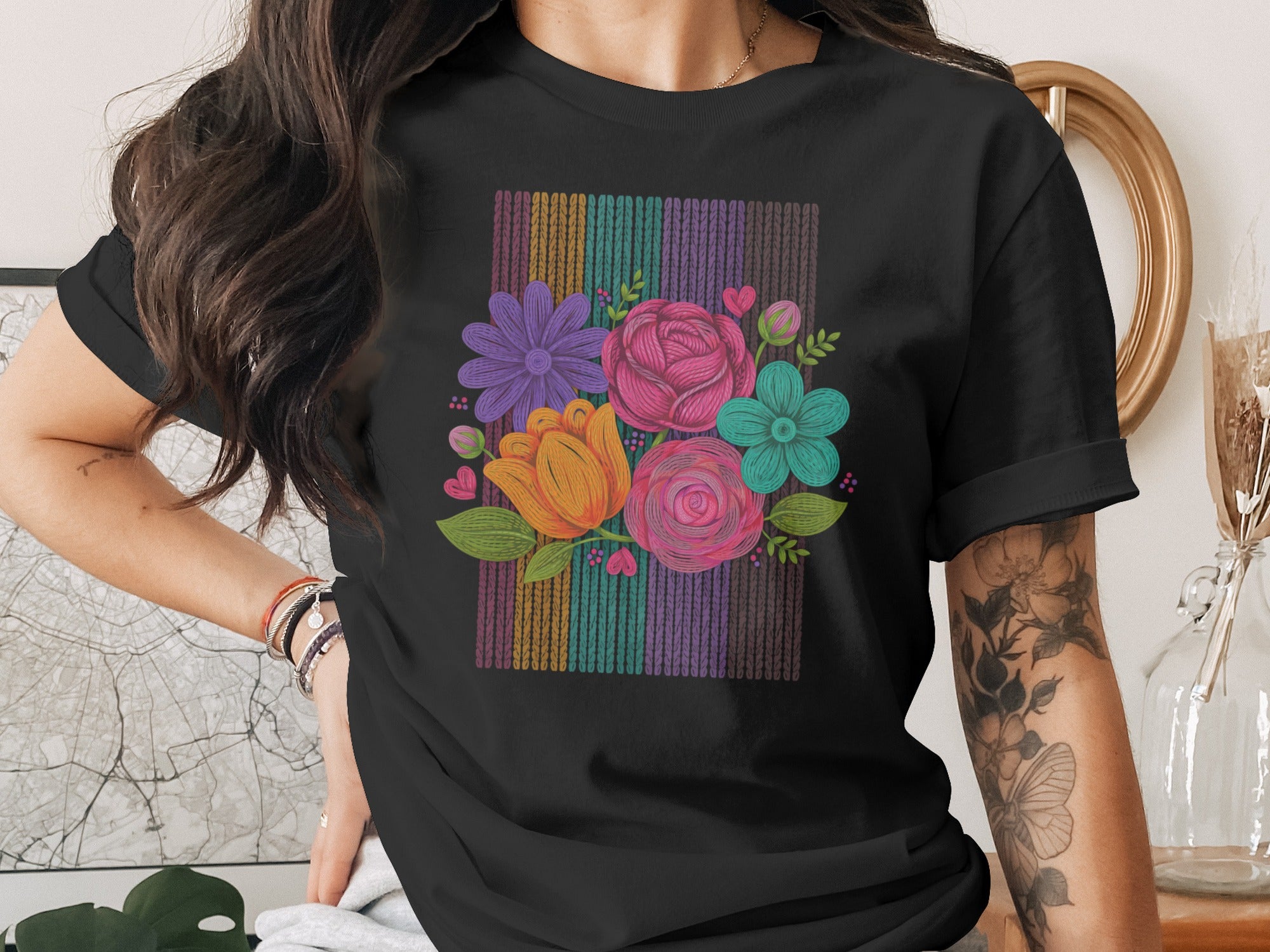 Black t-shirt with a colorful floral bouquet design against a striped background.